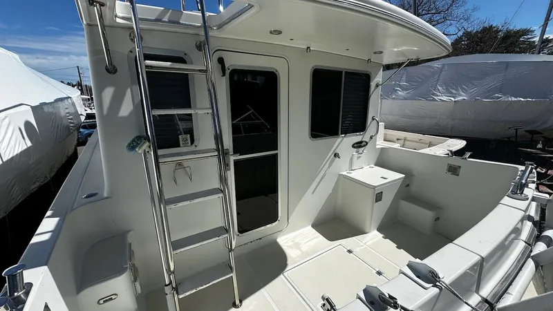 Leto Yacht Photos Pics American Tug 34, 2001 model, featuring a spacious deck with ladder and seating area.