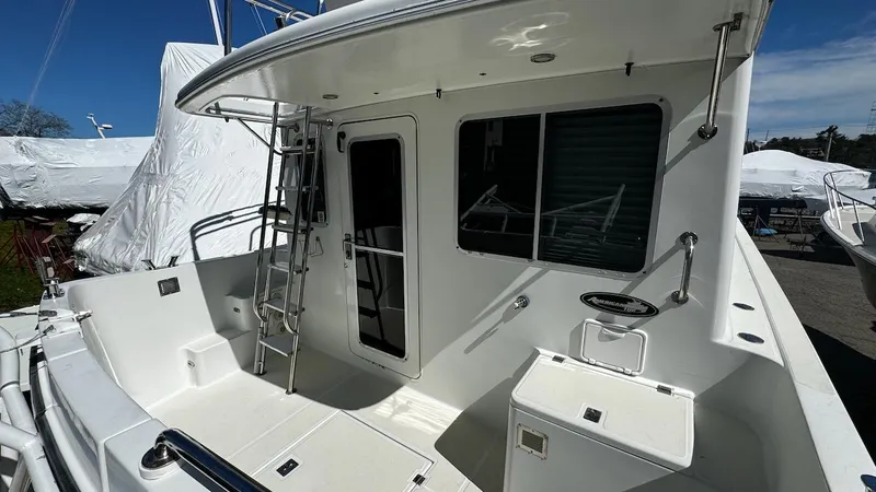 Leto Yacht Photos Pics American Tug 34, 2001 model, featuring a spacious deck with ladder and door access.