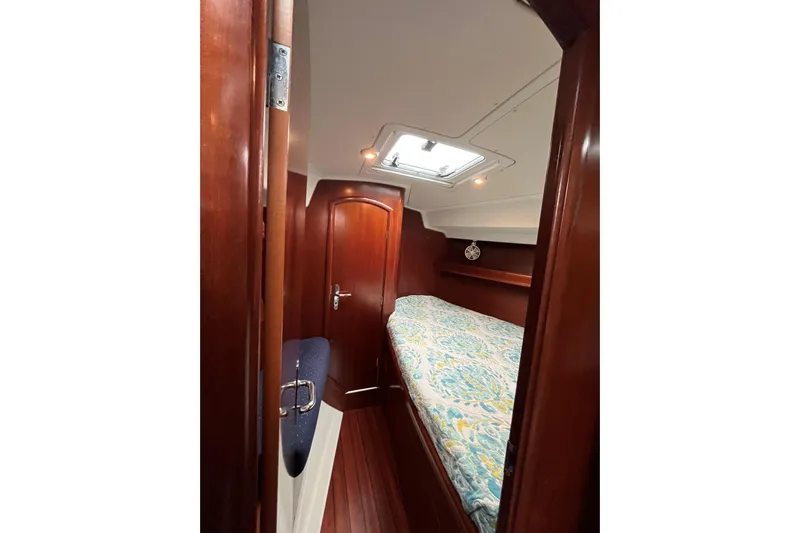  Yacht Photos Pics 2003 Beneteau Oceanis 42CC cabin interior with wood finish and patterned bedding.