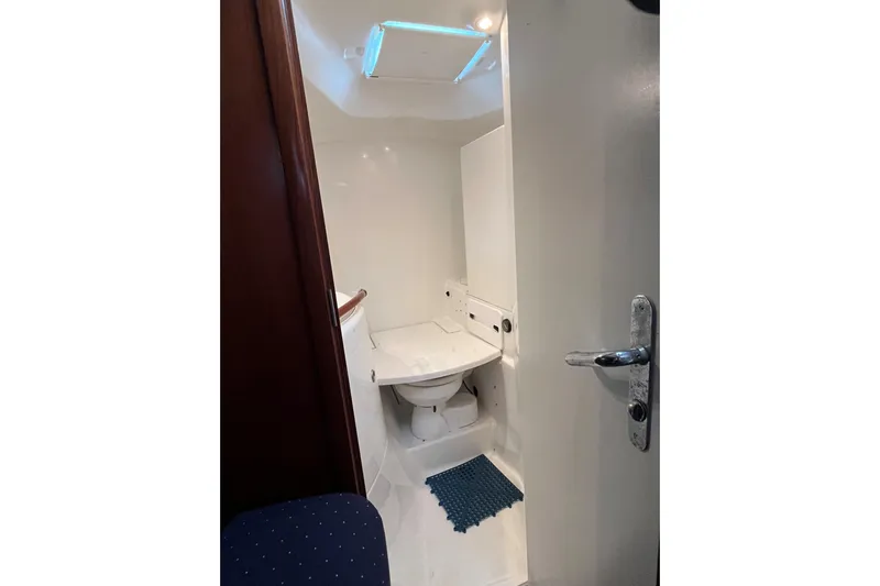  Yacht Photos Pics Bathroom interior of 2003 Beneteau Oceanis 42CC yacht, featuring compact design and skylight.