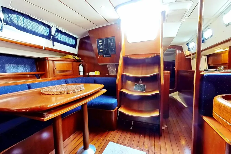Sea No Evil Yacht Photos Pics Interior of 2003 Beneteau Oceanis 42CC sailboat with wooden furnishings and seating area.