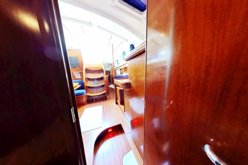 Sea No Evil Yacht Photos Pics Interior view of 2003 Beneteau Oceanis 42CC sailboat with wooden finishes and seating area.
