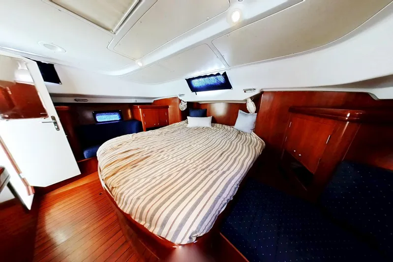 Sea No Evil Yacht Photos Pics Luxurious cabin interior of 2003 Beneteau Oceanis 42CC yacht with cozy bed and wood finish.