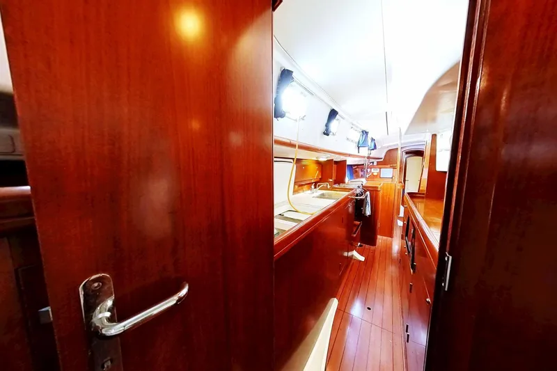 Sea No Evil Yacht Photos Pics Interior view of 2003 Beneteau Oceanis 42CC sailboat, featuring wooden cabinetry and flooring.