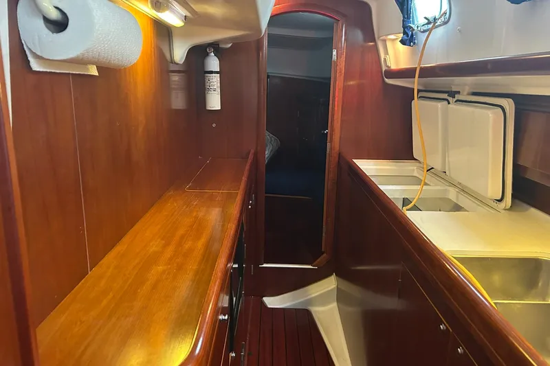 Sea No Evil Yacht Photos Pics Interior of 2003 Beneteau Oceanis 42CC yacht with wooden cabinetry and kitchen area.