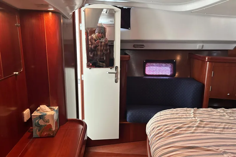 Sea No Evil Yacht Photos Pics Interior of 2003 Beneteau Oceanis 42CC yacht with wood finish and cozy seating area.