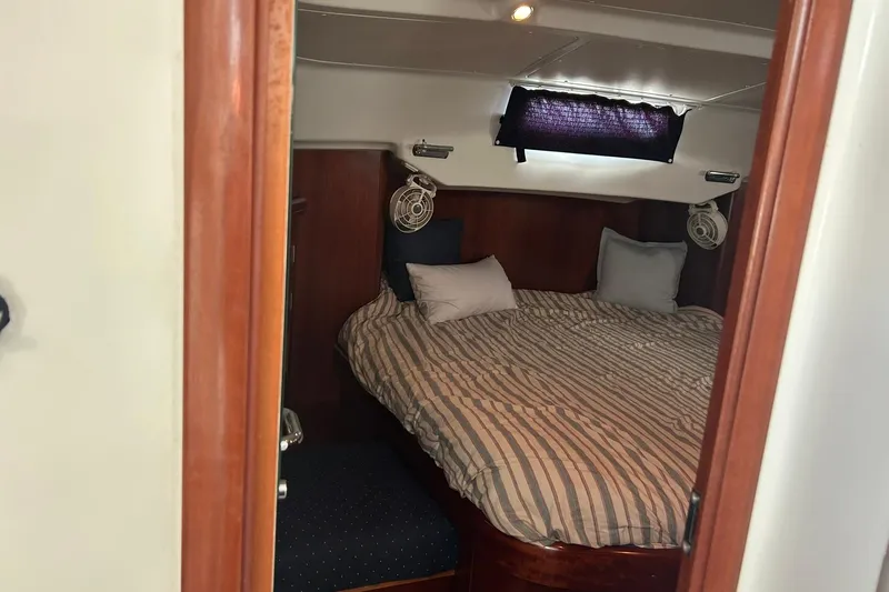 Sea No Evil Yacht Photos Pics Cozy cabin interior of 2003 Beneteau Oceanis 42CC sailboat with striped bedding.