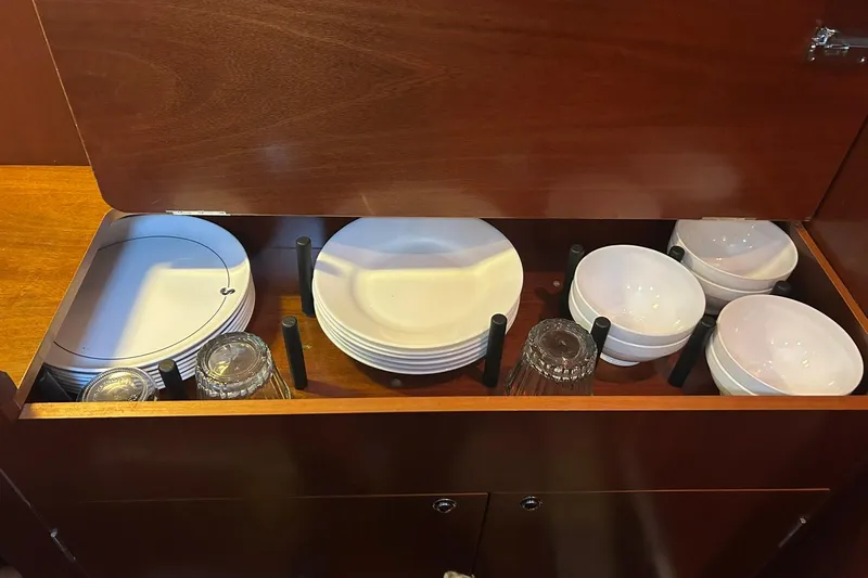 Sea No Evil Yacht Photos Pics Cabinet with dishes and glasses on a 2003 Beneteau Oceanis 42CC yacht.