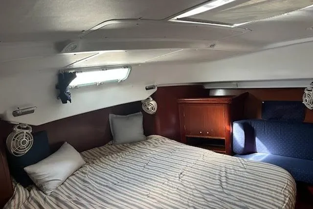 Sea No Evil Yacht Photos Pics Cozy cabin interior of 2003 Beneteau Oceanis 42CC sailboat with bed and seating area.
