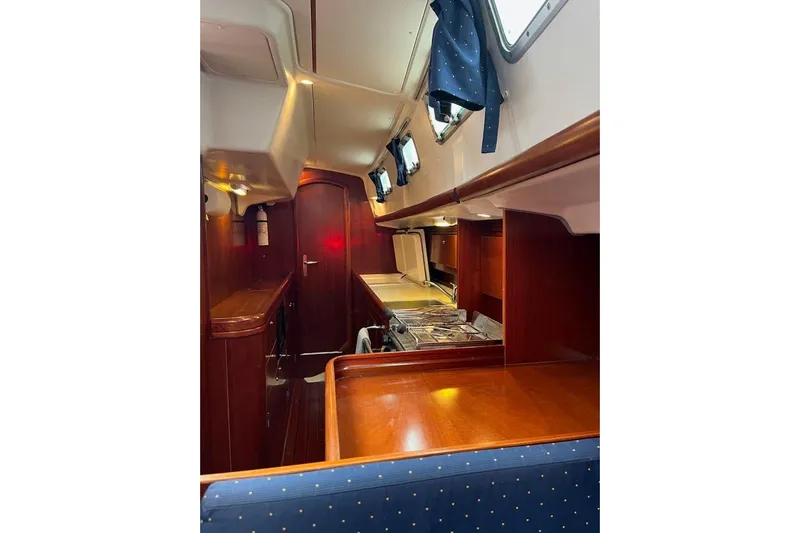 Sea No Evil Yacht Photos Pics Interior of 2003 Beneteau Oceanis 42CC sailboat with wood finish and compact kitchen.