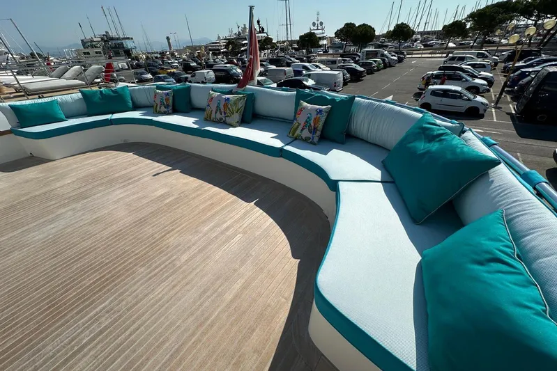  Yacht Photos Pics Luxurious seating area on 2021 Terranova Yachts T85, featuring turquoise cushions and scenic marina view.