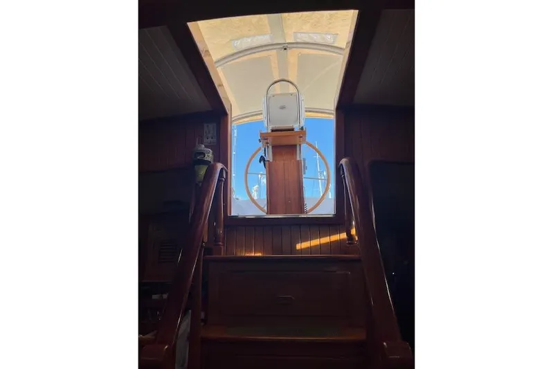 Wind Star Yacht Photos Pics Interior view of 1986 Liberty 49 yacht, showcasing wooden stairs and helm station.