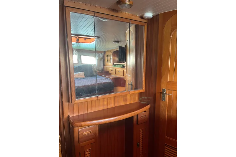 Wind Star Yacht Photos Pics Wooden interior of 1986 Liberty 49 boat with mirrored cabinet and cozy bedroom view.