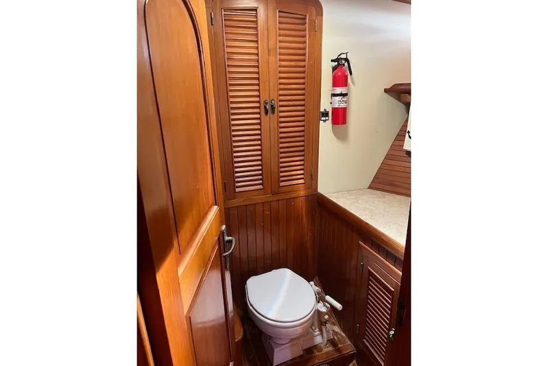 Wind Star Yacht Photos Pics 1986 Liberty 49 yacht bathroom with wooden cabinetry and fire extinguisher.
