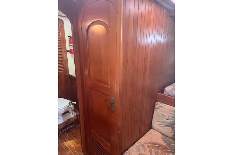 Wind Star Yacht Photos Pics Wooden interior of 1986 Liberty 49 boat, featuring a door and visible toilet.