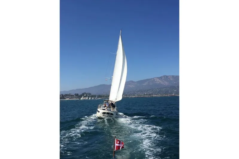 Wind Star Yacht Photos Pics Sailboat "Wind Star" on ocean, Liberty 49 model, 1986, with scenic mountain backdrop.