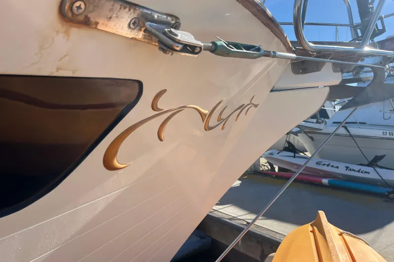 Wind Star Yacht Photos Pics 1986 Liberty 49 boat with elegant gold script on the hull, docked at a marina.