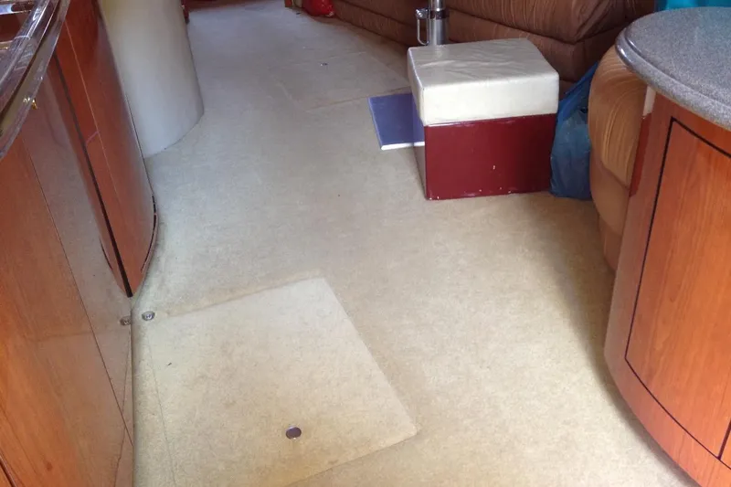 Good News Yacht Photos Pics Interior of 1998 Sea Ray 540 Sundancer yacht with beige carpet and wooden cabinetry.