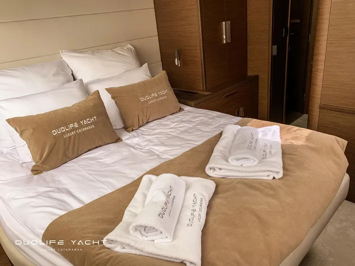 Duolife Yacht Yacht Photos Pics Luxurious bedroom interior of 2019 Lagoon 620 yacht with plush bedding and towels.