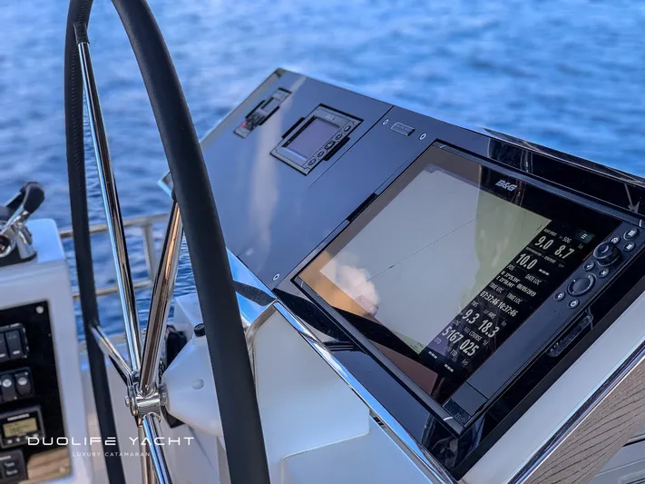 Duolife Yacht Yacht Photos Pics Steering wheel and navigation display on 2019 Lagoon 620 yacht, overlooking the ocean.
