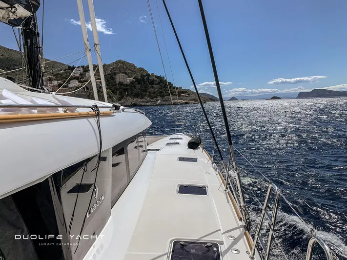 Duolife Yacht Yacht Photos Pics 2019 Lagoon 620 catamaran sailing on a sunny day with scenic coastal views.