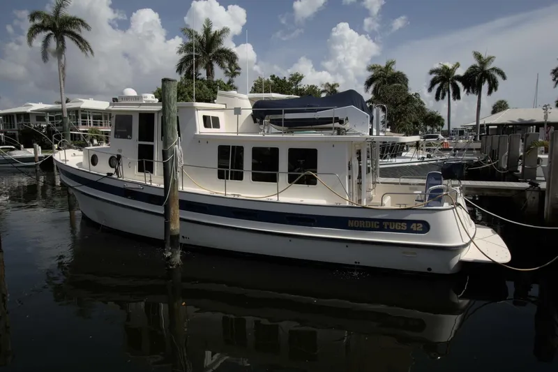 Hercules Yacht Photos Pics Nordic Tug 42 Millennium 2000 docked at marina with palm trees in background.