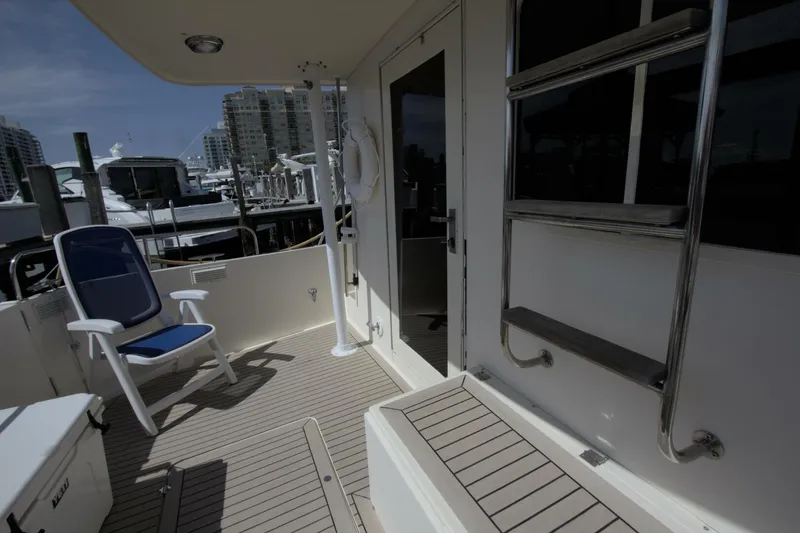 Hercules Yacht Photos Pics Deck of 2000 Nordic Tug 42 Millennium with chair and ladder, docked at marina.