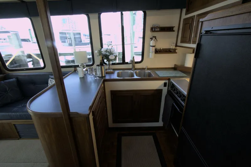 Hercules Yacht Photos Pics Interior of 2000 Nordic Tug 42 Millennium, featuring a compact kitchen with wooden cabinetry.