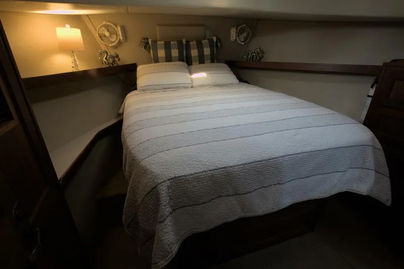 Hercules Yacht Photos Pics Cozy bedroom in 2000 Nordic Tug 42 Millennium yacht with striped bedding and warm lighting.