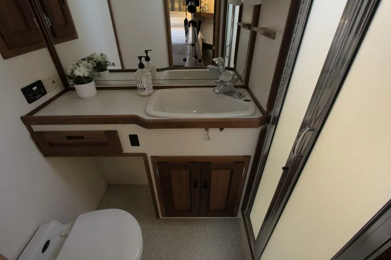 Hercules Yacht Photos Pics Bathroom interior of 2000 Nordic Tug 42 Millennium with sink, mirror, and shower.
