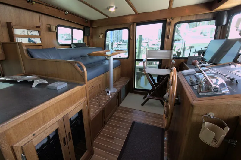 Hercules Yacht Photos Pics Interior of 2000 Nordic Tug 42 Millennium, featuring helm, seating, and wooden cabinetry.