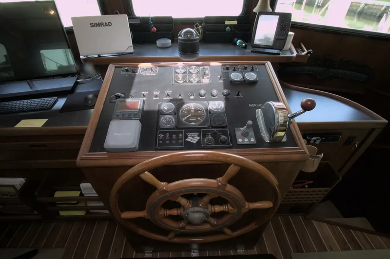 Hercules Yacht Photos Pics Helm of 2000 Nordic Tug 42 Millennium with navigation equipment and wooden steering wheel.