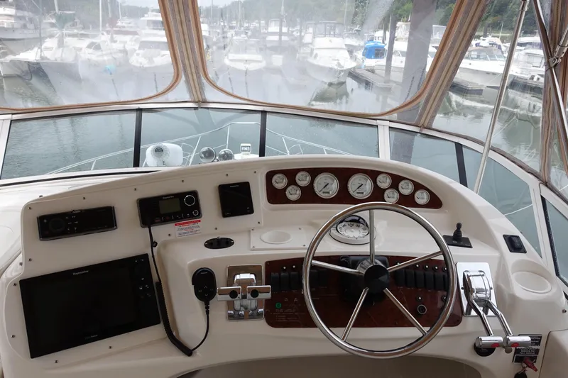  Yacht Photos Pics 2001 Silverton 410 Sport Bridge helm with gauges, steering wheel, and marina view.