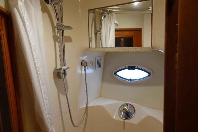  Yacht Photos Pics Bathroom interior of 2001 Silverton 410 Sport Bridge yacht, featuring shower and porthole window.
