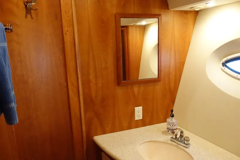 Yacht Photos Pics 2001 Silverton 410 Sport Bridge bathroom with wooden paneling and oval window.