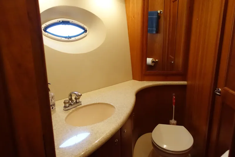  Yacht Photos Pics Luxurious bathroom in 2001 Silverton 410 Sport Bridge yacht with wood accents and porthole window.