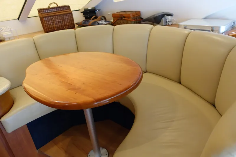  Yacht Photos Pics 2001 Silverton 410 Sport Bridge interior with curved beige seating and wooden table.