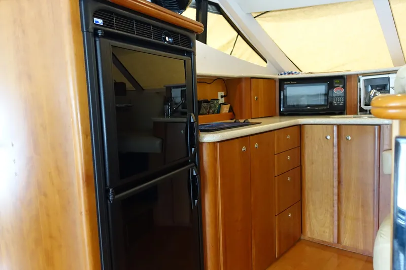  Yacht Photos Pics 2001 Silverton 410 Sport Bridge yacht interior kitchen with wood cabinets and appliances.