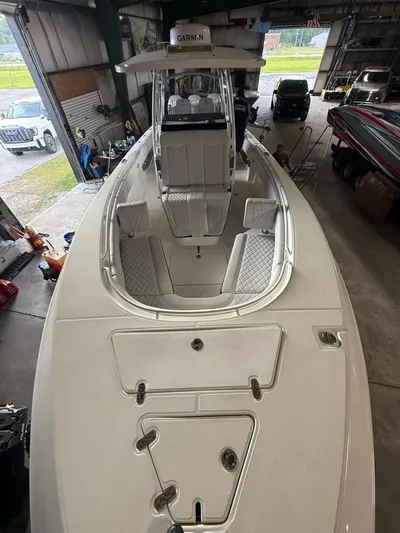 Yacht Photos Pics 2023 Fountain 34 CC boat in a garage, showcasing spacious deck and seating.