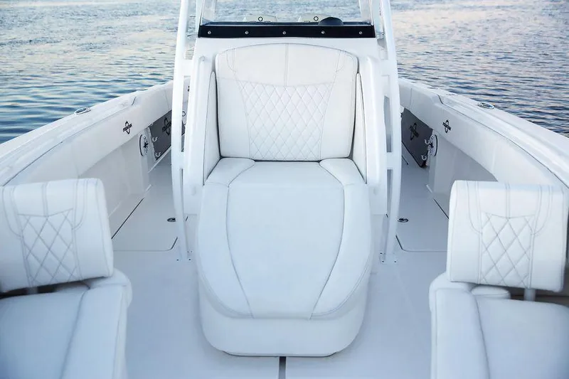 Fountain 34 Cc Yacht Photos Pics 2023 Fountain 34 CC boat interior with white cushioned seating on calm water.