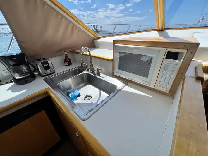 Fantasea Yacht Photos Pics Navigator 43 Flybridge 1994 yacht kitchen with sink, microwave, coffee maker, and ocean view.
