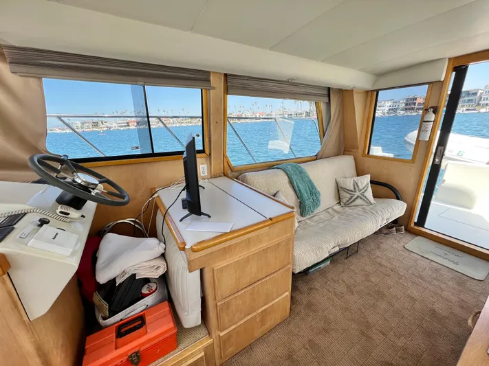 Fantasea Yacht Photos Pics Navigator 43 Flybridge 1994 interior with helm, sofa, and waterfront view.