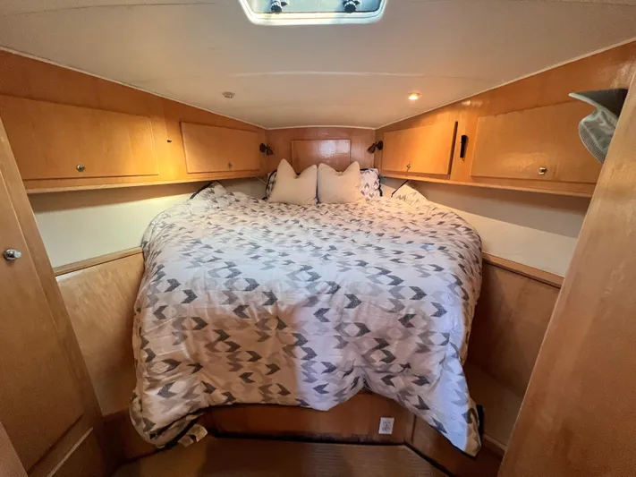 Fantasea Yacht Photos Pics 1994 Navigator 43 Flybridge bedroom with cozy bed and wooden cabinets.