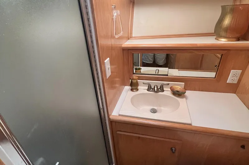 Fantasea Yacht Photos Pics Navigator 43 Flybridge 1994 yacht bathroom with sink, mirror, and frosted glass shower.