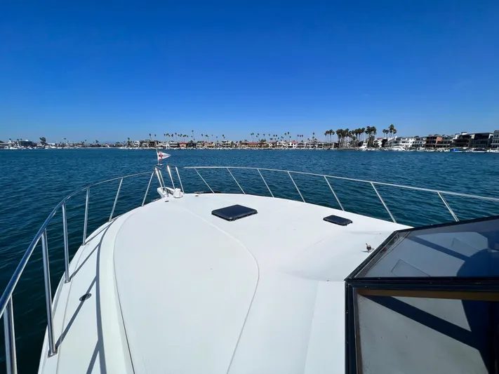 Fantasea Yacht Photos Pics 1994 Navigator 43 Flybridge yacht on calm waters with coastal view.