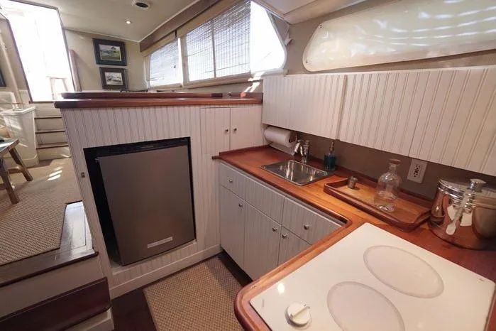 Faith Yacht Photos Pics Interior of 2003 Huckins Atlantic 44 yacht kitchen with modern amenities and wood accents.