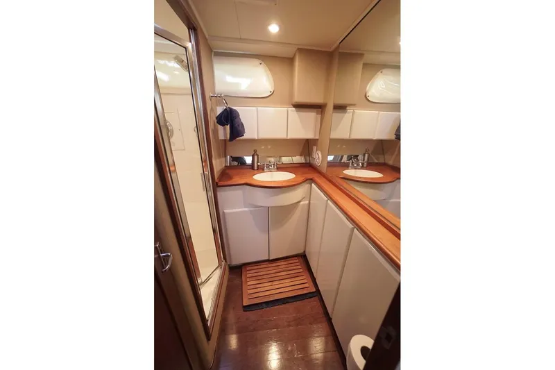 Faith Yacht Photos Pics Luxurious bathroom interior of 2003 Huckins Atlantic 44 yacht with wooden accents.