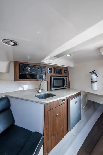 Kirby 107 Yacht Photos Pics 2014 Everglades 350LX cabin interior with kitchenette, sink, microwave, and fire extinguisher.
