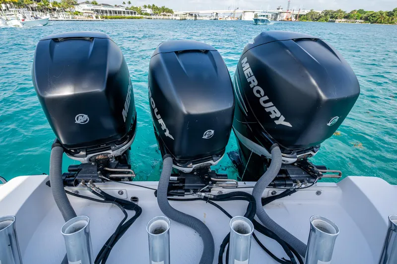 Kirby 107 Yacht Photos Pics Triple Mercury outboard engines on a 2014 Everglades 350LX boat in clear blue water.