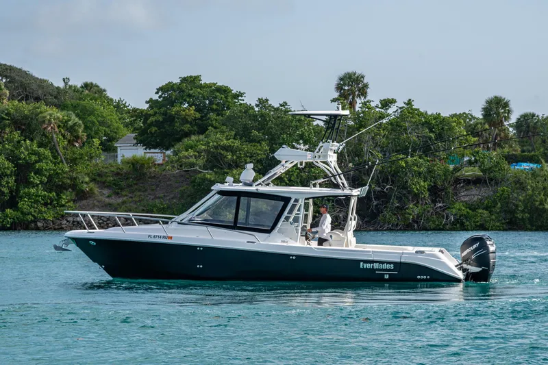 Kirby 107 Yacht Photos Pics 2014 Everglades 350LX boat cruising on a serene waterway with lush greenery.